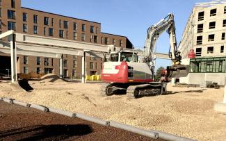 Construction vehicles can be used on the stable ZinCo system build-up without a problem. © Malmos A/S / ZinCo Excavator on a roof area filled with substrate